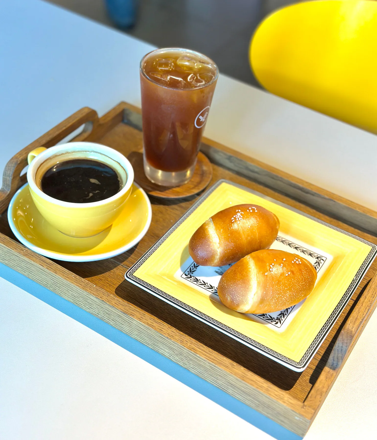 黄色い皿の塩パン2個と黄色いカップのドリップコーヒー、アイスコーヒー
